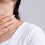 Un chica se toca el cuello